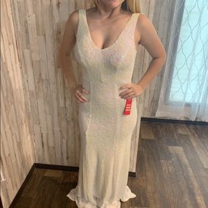 White floor length sequined formal gown with hints of pink and yellow shimmer